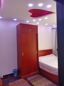a small bedroom with a bed and a wooden cabinet at شاليهات بورتو مطروح فيو بحر Porto Matrouh Sea View Families Only in Marsa Matruh