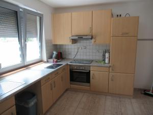 a kitchen with wooden cabinets and a sink and a window at WeCo Ferienwohnungen in Zirndorf