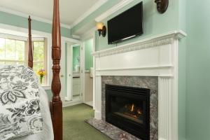 a living room with a fireplace with a tv above it at 1802 House Bed & Breakfast in Kennebunkport