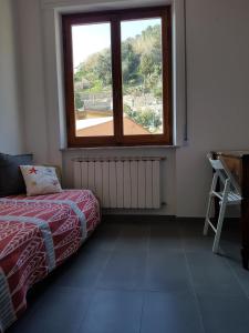 a bedroom with a window and a bed and a table at GIOBEA New Aptm with A/C in Monterosso al Mare