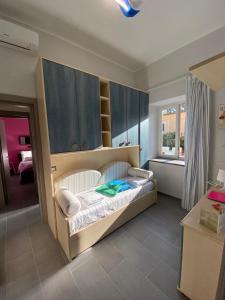 una camera da letto con un letto con armadi blu e una finestra di La Casetta di Ludo a Ischia