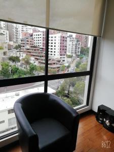una silla negra sentada frente a una gran ventana en Ejecutivo Vista a Quito, Cerca a la Carolina, en Quito