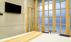a bedroom with a bed and a large window at Hotel Rooms Dadar near Station in Mumbai
