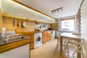 a kitchen with a sink and a washing machine at Apartamenty Mewa in Rewa
