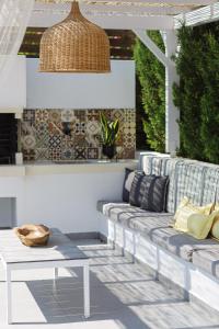 a patio with a couch and a table at Chara Sensory Luxury Villa with Heated Pool & Gym, By ThinkVilla in Panormos Rethymno