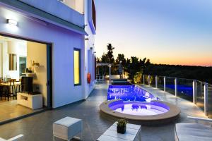 a house with a hot tub on a balcony at Chara Sensory Luxury Villa with Heated Pool & Gym, By ThinkVilla in Panormos Rethymno