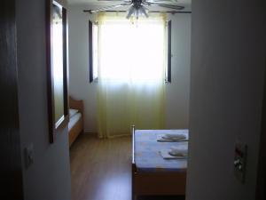 a room with a table and a window with a ceiling fan at Villa Welcome in Vrboska