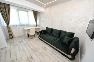 ein Wohnzimmer mit einem grünen Sofa und einem Tisch in der Unterkunft Sweet Luxury - CentralPark in Galaţi