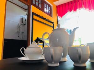 a table with a tea pot and cups on it at Grand Camellia Hotel in Ambalantota