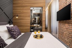 a hotel room with a bed with two glasses of wine at Luxury Number 1 Apartments in Rijeka