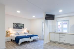 1 dormitorio blanco con 1 cama con manta azul en MIRADOR DE LA MURALLA, en Betanzos