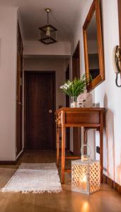 corridoio con tavolo in legno e specchio di Vizinha's Apartment a Ponta Delgada