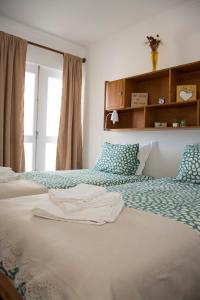 - une chambre avec 2 lits et une fenêtre dans l'établissement Vizinha's Apartment, à Ponta Delgada