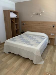 a bedroom with a bed and a wooden floor at Hotel Bellevue in Saint-Florent