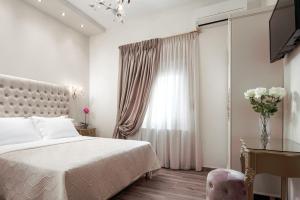a white bedroom with a bed and a window at Eleana Luxury Private Apartment in Neos Marmaras
