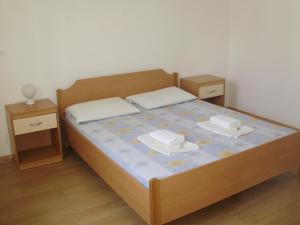 a bedroom with a bed with two nightstands and two tables at Villa Welcome in Vrboska