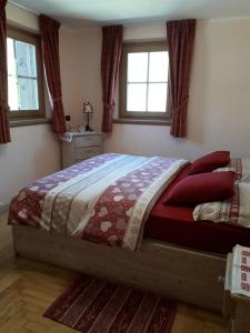 リヴィーニョにあるChalet Pilaのベッドルーム1室(赤い枕と窓付きのベッド1台付)