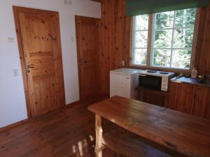 a kitchen with wooden walls and a table and a window at Marta-Lovise puhkemaja Kristiine in Kipi