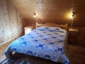 a bedroom with a bed in a wooden cabin at Marta-Lovise puhkemaja Kristiine in Kipi