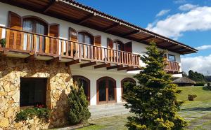 uma casa grande com uma varanda em cima em Pousada Mansão Edelweiss em Campos do Jordão