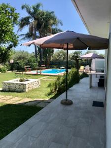 a patio with an umbrella next to a pool at Casa vacanza le tre palme in Floridia