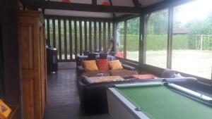 a screened in porch with a pool table at La ferme aux Perdrix in Beuvron-en-Auge