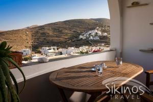 una mesa de madera en una habitación con vistas a la montaña en Anna's House en Síkinos