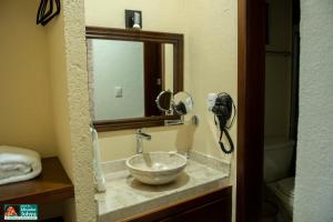 a bathroom with a bowl sink with a mirror at Mirador Johya Hotel in Bernal