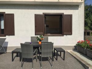 una mesa de patio y sillas con un edificio en Casa Silvia, en Ledro