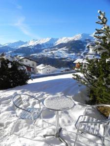 una mesa y dos sillas en la nieve en Haus Edelweiss, en Fendels