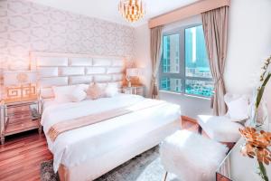 a bedroom with a large white bed and a window at Elite Royal Apartment - Burj Residences T5 | VIP in Dubai