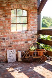 a wooden cart sitting next to a brick wall at Blumenhuhnhof in Burg Kauper