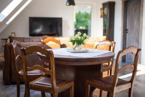 ein Tisch und Stühle mit einer Blumenvase drauf in der Unterkunft Blumenhuhnhof in Burg Kauper