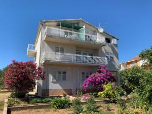 een appartementencomplex met een balkon en bloemen bij Roca Apartments in Vodice