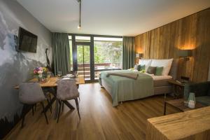 a bedroom with a bed and a desk and a table with chairs at Schlosspark Grubhof - Mitterer in Sankt Martin bei Lofer