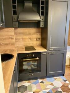 a small kitchen with a stove and a sink at Boutique Magenta Gold Apartment in Sofia