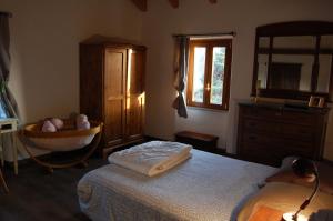 a bedroom with a bed and a crib and a dresser at Ca' de l'Ase in Pontinvrea