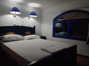 a bedroom with a bed with two lamps and a window at Blue Sky Aparts in Livadia