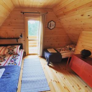 sypialnia z 2 łóżkami w drewnianym domku w obiekcie Bajka Domek na Roztoczu w mieście Bondyrz