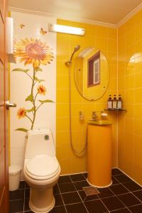 a yellow bathroom with a toilet and a flower on the wall at CHAEUL Pension in Pyeongchang