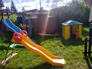 einen Spielplatz mit Rutsche im Gras in der Unterkunft Willa Cosmos & Champion in Iława