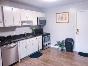 a kitchen with white cabinets and a stainless steel appliance at Downtown Apartment convenient to all city venues 105 in Greensboro
