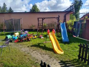 einen Spielplatz mit Rutschen und Spielzeug im Gras in der Unterkunft Willa Cosmos & Champion in Iława