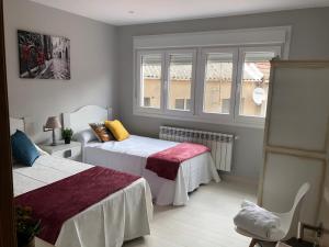 a bedroom with two beds and a window at Apartamento Adelina in Silleda