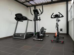 un gimnasio con 3 bicicletas estáticas en una habitación en Arame Hotel en Envigado