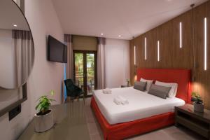 a bedroom with a large bed with a red headboard at Villa Sonia in Malia