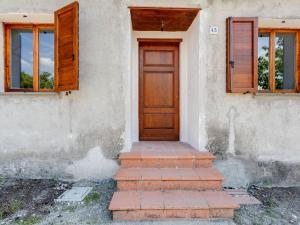 una casa con una puerta de madera y algunas escaleras en Belvilla by OYO Casa Andrea, en Sparti