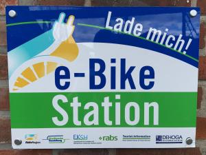 ein Schild für eine Fahrradstation an einer Wand in der Unterkunft Hotel O'felder in Osterrönfeld