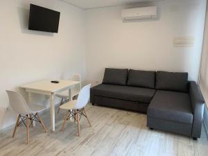 a living room with a couch and a table at Apartamento 1ª linea by Hugo Beach Hotel - Familias in Gandía