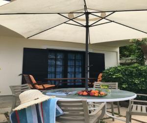 un tavolo con ombrellone su un patio di Aigialis Apartments & Studios a Kokkíni Khánion